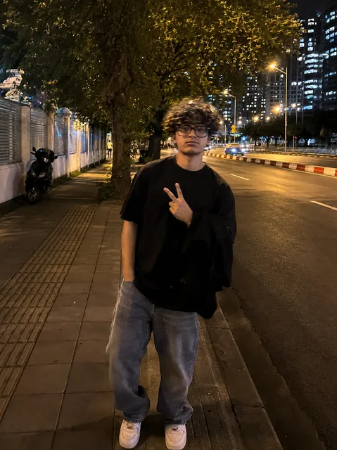 Samiel standing on a city street at night