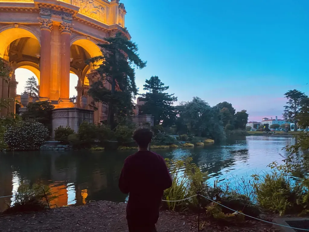 Samiel beside a lagoon and illuminated arches at blue hour